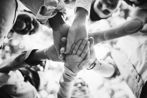 A group of people in a circle joining hands together