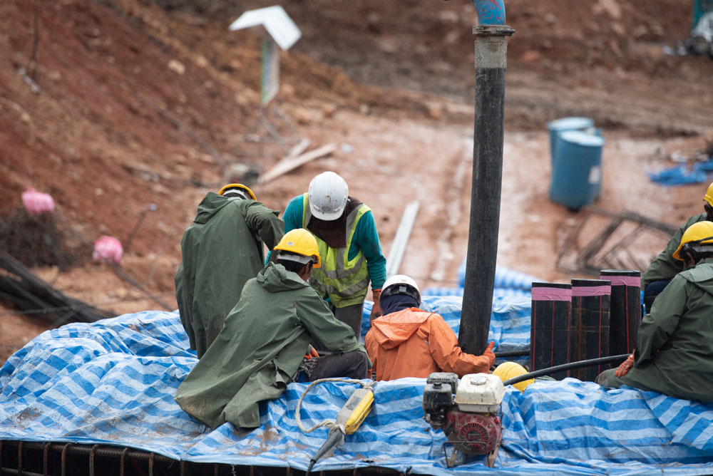 Construction workers resting on the side of a construction site