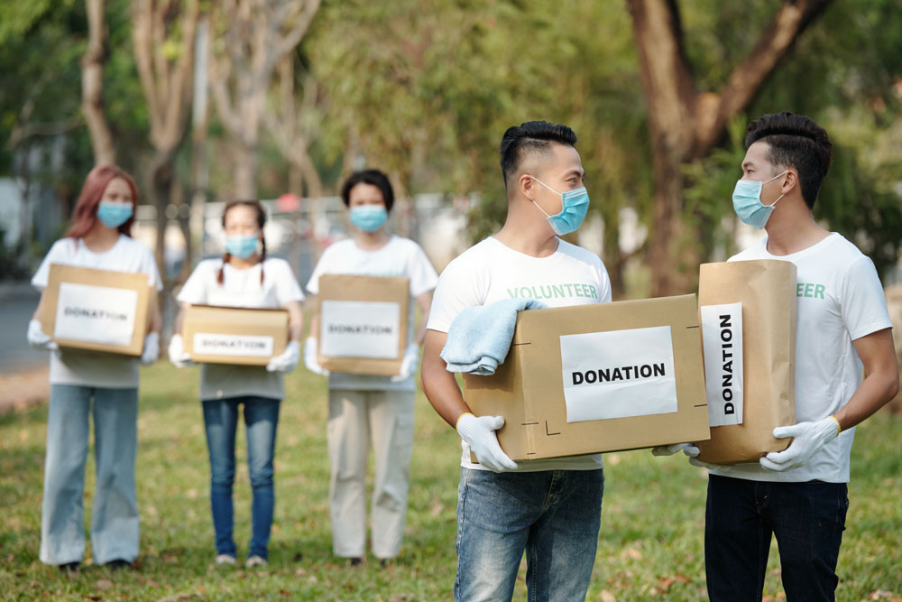 Volunteers carrying bags and boxes labelled donation